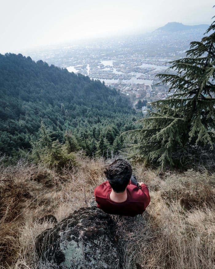 Man In Red Long Sleeve Shirt Sitting On Rock